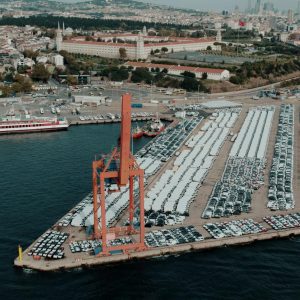 Aerial view of a bustling car shipping terminal in Istanbul, Türkiye, showcasing a busy port with vehicles ready for export.